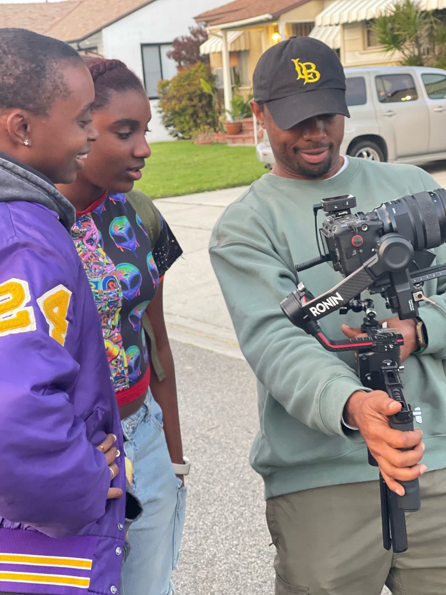 Q Burdette on set holding a camera