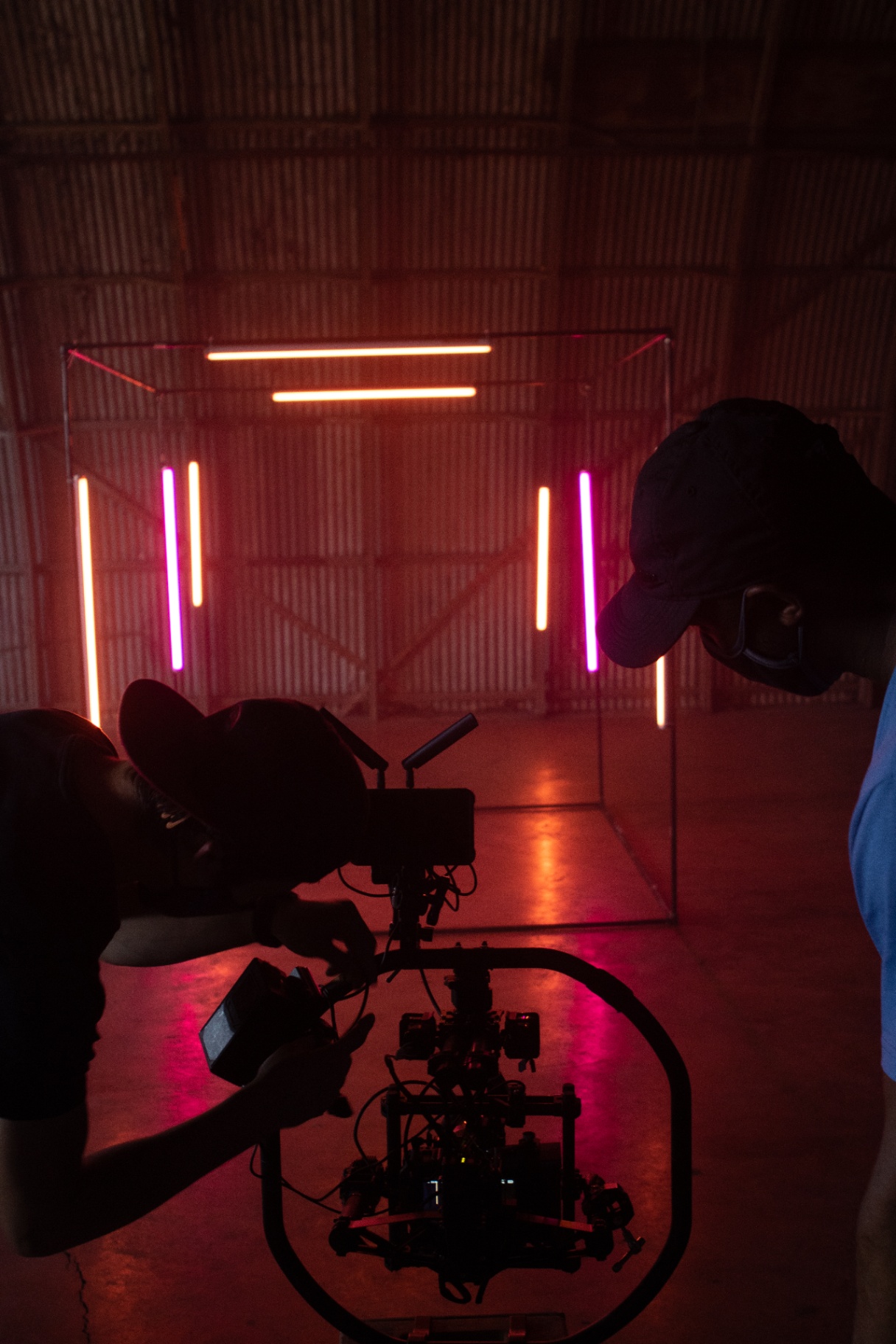 Operator lining up a gimbal shot inside a red-tube warehouse cube