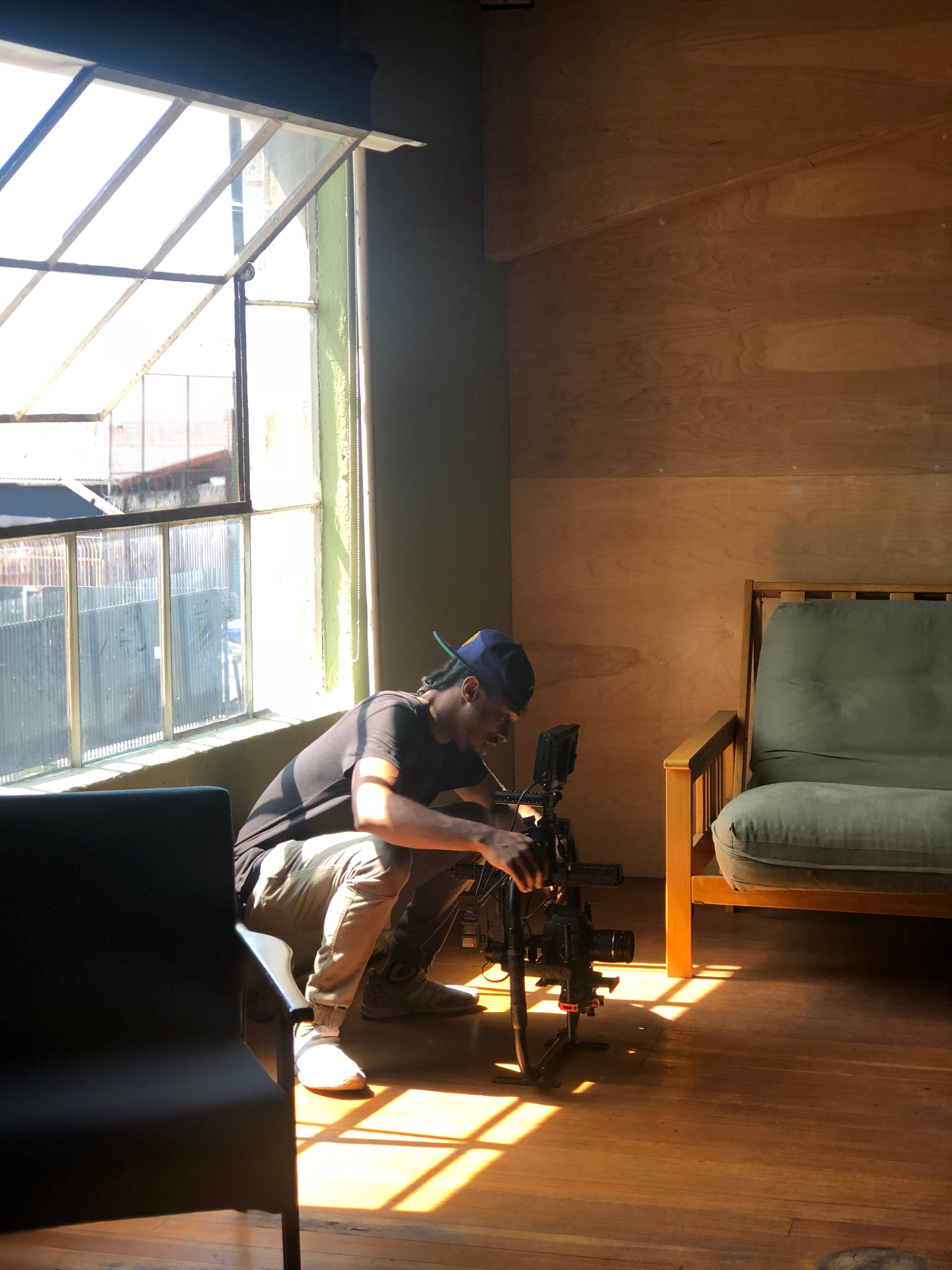 Q operating a cinema camera in warm golden hour light