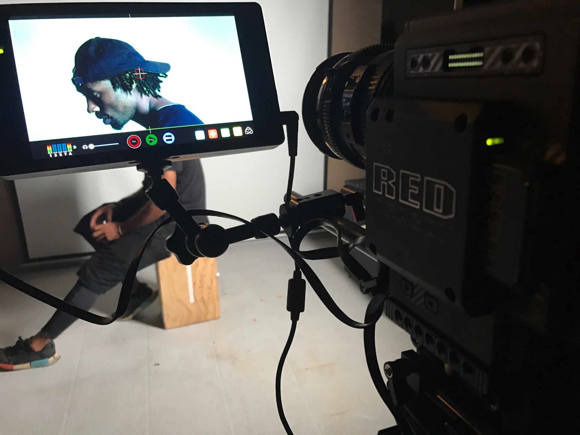 On-set monitor lit in warm golden-hour light beside the camera rig