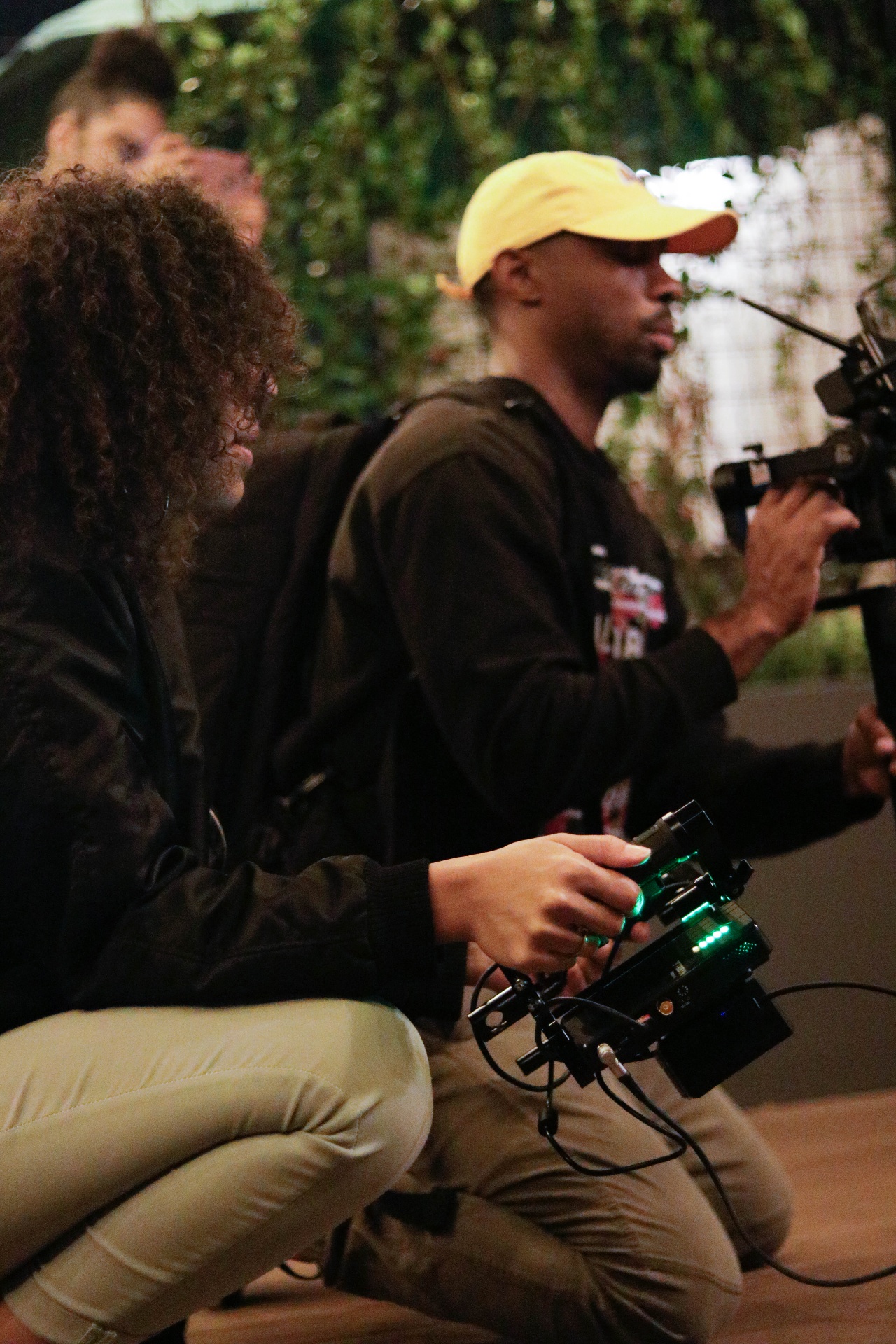 Focus puller and operator against a green ivy wall