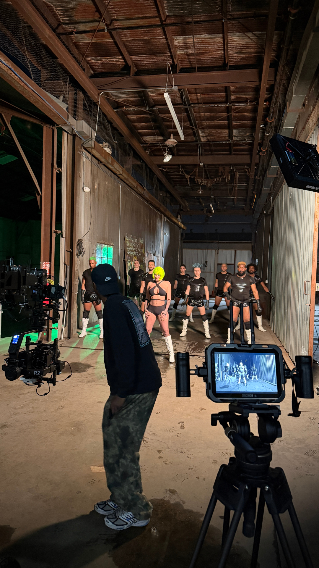 Q directing at the monitor with talent on set